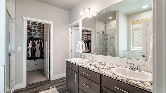 4011 S University Ct, Spokane Valley, WA 99206 - bathroom with a walk in closet, double vanity, wood finished floors, a stall shower, and baseboards