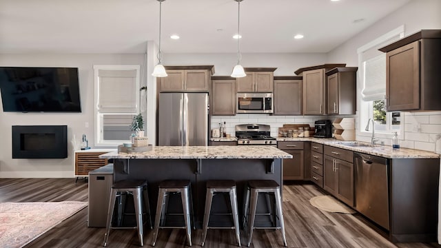 4011 S University Ct, Spokane Valley, WA 99206 - kitchen featuring stainless steel appliances, a sink, backsplash, dark wood-type flooring, and light stone counters