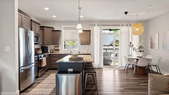 4011 S University Ct, Spokane Valley, WA 99206 - kitchen with appliances with stainless steel finishes, dark wood finished floors, backsplash, light stone counters, and a sink