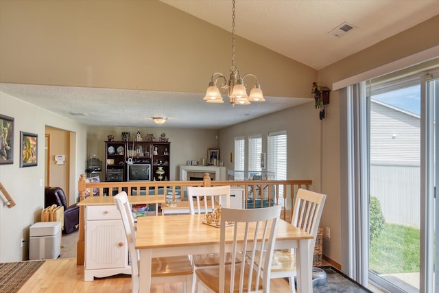 822 N Kelsea St, Medical Lake, WA 99022 - dining space featuring lofted ceiling, a chandelier, a fireplace, and light wood-style floors
