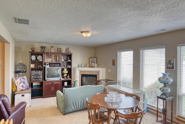 822 N Kelsea St, Medical Lake, WA 99022 - dining room with a textured ceiling, a tile fireplace, and light carpet
