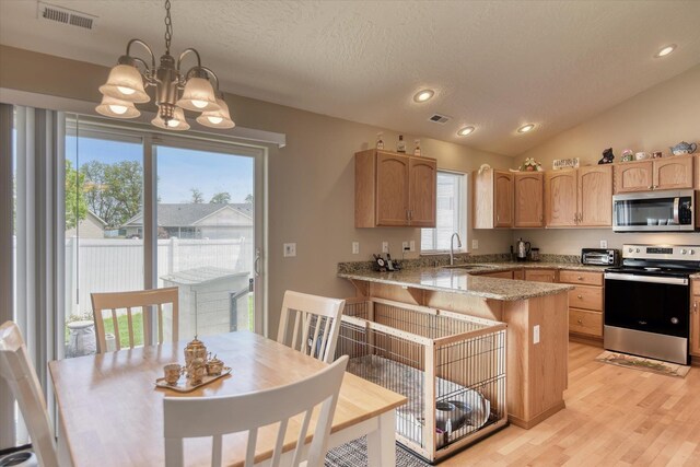 822 N Kelsea St, Medical Lake, WA 99022 - kitchen featuring stainless steel appliances, a sink, a chandelier, light wood-type flooring, and a peninsula