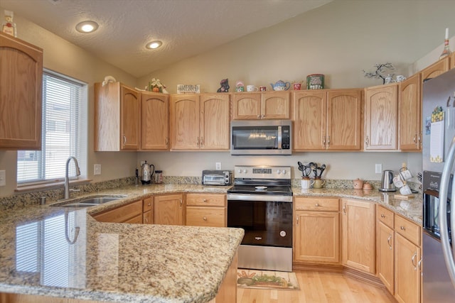 822 N Kelsea St, Medical Lake, WA 99022 - kitchen featuring stainless steel appliances, a sink, vaulted ceiling, light wood finished floors, and light stone counters