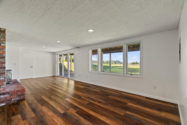 4626 E Orchard Rd, Spokane, WA 99217 - unfurnished living room featuring dark wood finished floors, a wood stove, baseboards, and recessed lighting