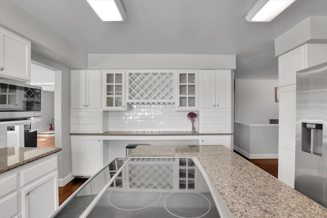4606 S Grove Rd, Spokane, WA 99224 - kitchen with appliances with stainless steel finishes, decorative backsplash, white cabinetry, glass insert cabinets, and light stone countertops