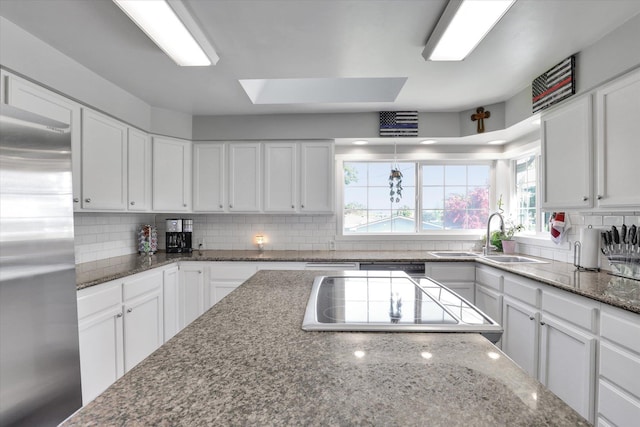 4606 S Grove Rd, Spokane, WA 99224 - kitchen featuring stainless steel refrigerator, a sink, decorative backsplash, and white cabinets