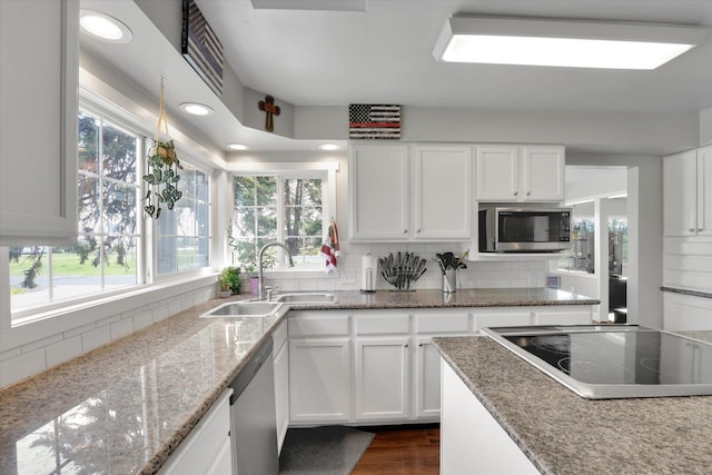 4606 S Grove Rd, Spokane, WA 99224 - kitchen featuring a sink, stainless steel appliances, decorative backsplash, white cabinets, and healthy amount of natural light
