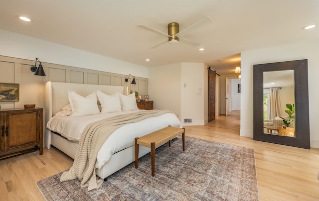 19009 N Little Spokane Dr, Colbert, WA 99005 - bedroom featuring light wood-type flooring, a barn door, recessed lighting, a ceiling fan, and baseboards