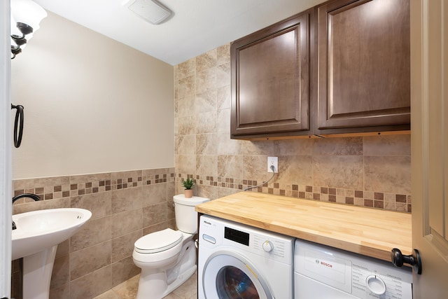 1641 E Crown Ave, Spokane, WA 99207 - half bath with tile walls, toilet, independent washer and dryer, a sink, and tile patterned flooring