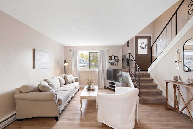 1641 E Crown Ave, Spokane, WA 99207 - living area with baseboard heating, a textured ceiling, stairway, wood finished floors, and baseboards