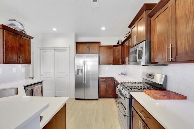 1725 S Donwood St, Spokane Valley, WA 99037 - kitchen with stainless steel appliances, tasteful backsplash, light countertops, light wood-style floors, and recessed lighting