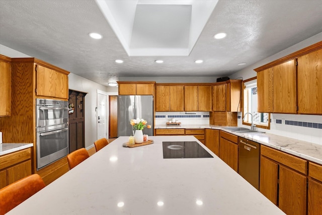 10102 N Comanche Dr, Spokane, WA 99208 - kitchen with appliances with stainless steel finishes, a sink, recessed lighting, brown cabinetry, and tasteful backsplash