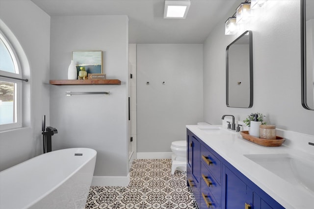 10102 N Comanche Dr, Spokane, WA 99208 - bathroom featuring double vanity, a freestanding tub, a stall shower, and baseboards