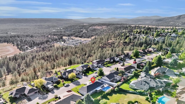 10102 N Comanche Dr, Spokane, WA 99208 - aerial view of property and surrounding area featuring a heavily wooded area, a mountain backdrop, and nearby suburban area