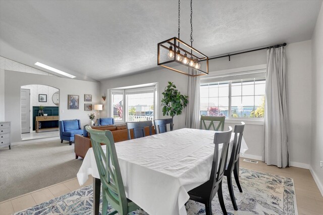 10102 N Comanche Dr, Spokane, WA 99208 - dining room with a chandelier, light wood-type flooring, a textured ceiling, arched walkways, and baseboards