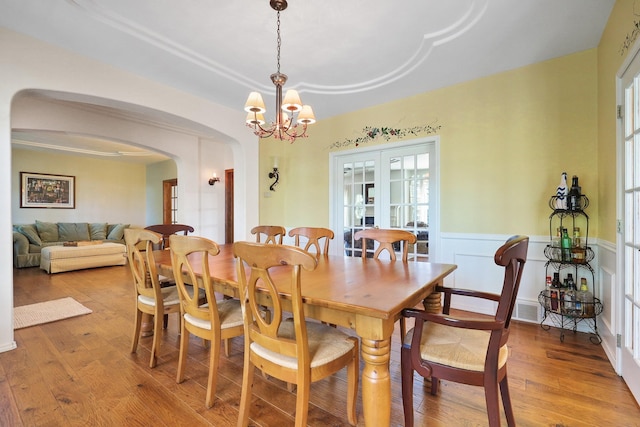 5711 E Nancy Ln, Mead, WA 99021 - dining area featuring arched walkways, light wood-style floors, a chandelier, and wainscoting