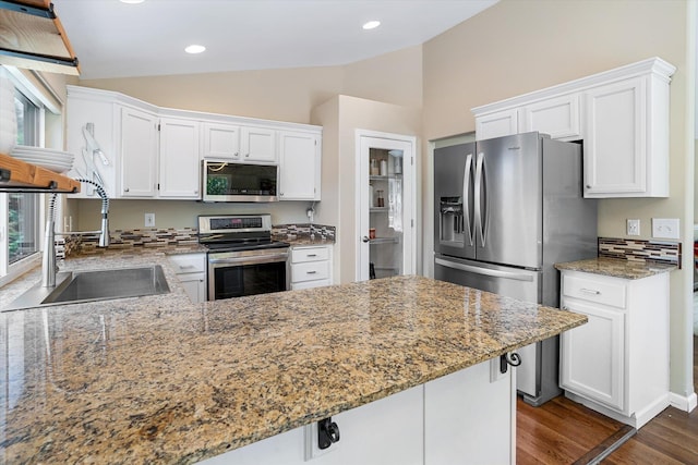 1725 N Mcmillan Ln, Spokane Valley, WA 99016 - kitchen with stainless steel appliances, vaulted ceiling, a sink, white cabinetry, and dark wood-style floors