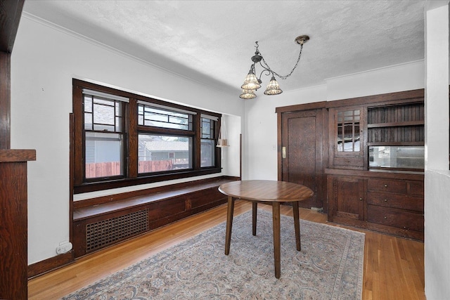 617 W Carlisle Ave, Spokane, WA 99205 - dining space with wood finished floors, a textured ceiling, ornamental molding, and a chandelier