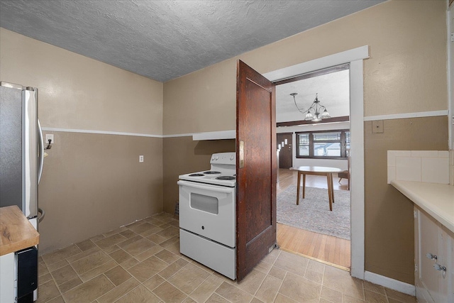 617 W Carlisle Ave, Spokane, WA 99205 - kitchen featuring white electric range oven, a chandelier, freestanding refrigerator, and a textured ceiling