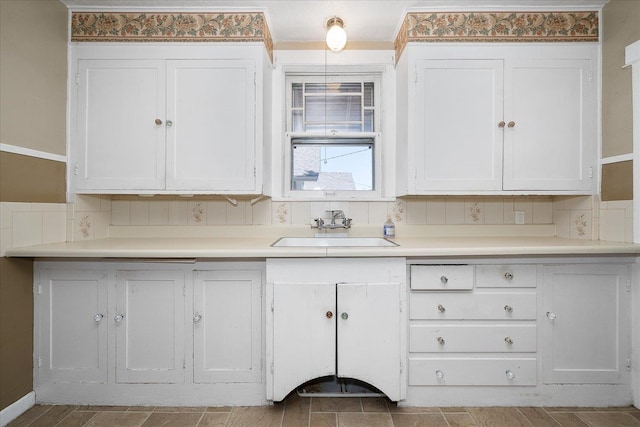 617 W Carlisle Ave, Spokane, WA 99205 - kitchen with a sink, white cabinetry, light countertops, and baseboards