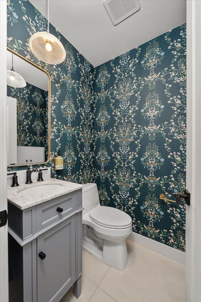 617 W Carlisle Ave, Spokane, WA 99205 - bathroom featuring toilet, wallpapered walls, vanity, tile patterned floors, and baseboards