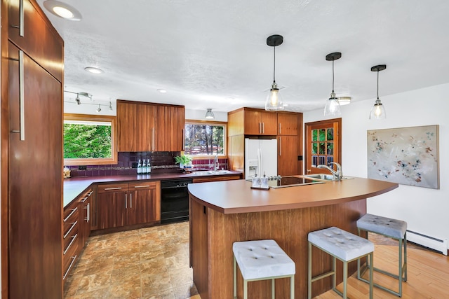 10401 N College Cir, Spokane, WA 99218 - kitchen featuring black appliances, decorative backsplash, a baseboard heating unit, a sink, and a breakfast bar area