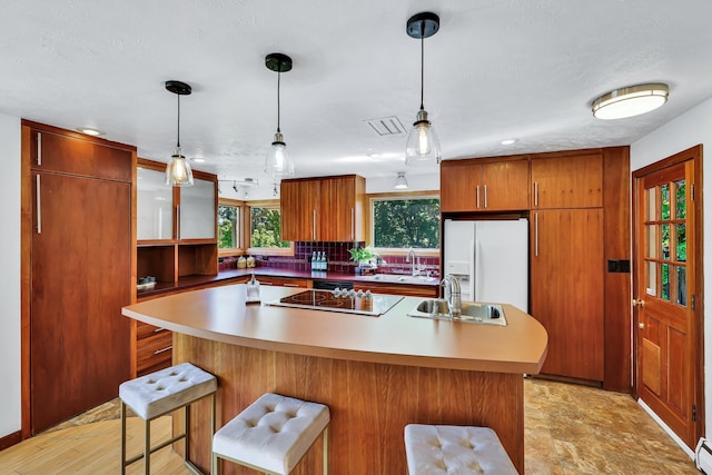 10401 N College Cir, Spokane, WA 99218 - kitchen with white fridge with ice dispenser, a sink, a center island, and pendant lighting