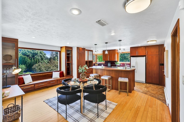 10401 N College Cir, Spokane, WA 99218 - dining room with plenty of natural light, light wood-style floors, recessed lighting, and a textured ceiling