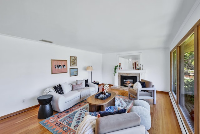 10401 N College Cir, Spokane, WA 99218 - living room with light wood-style flooring, baseboards, a glass covered fireplace, and a baseboard radiator