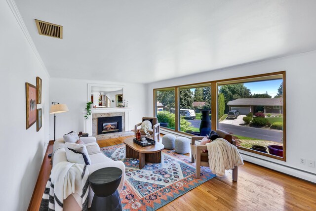 10401 N College Cir, Spokane, WA 99218 - living room featuring a glass covered fireplace, wood finished floors, crown molding, and a baseboard radiator