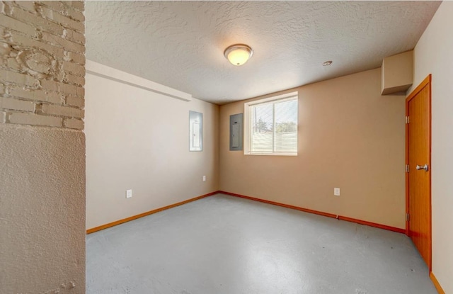 18 N 7th St, Cheney, WA 99004 - empty room featuring electric panel, baseboards, a textured ceiling, and concrete flooring