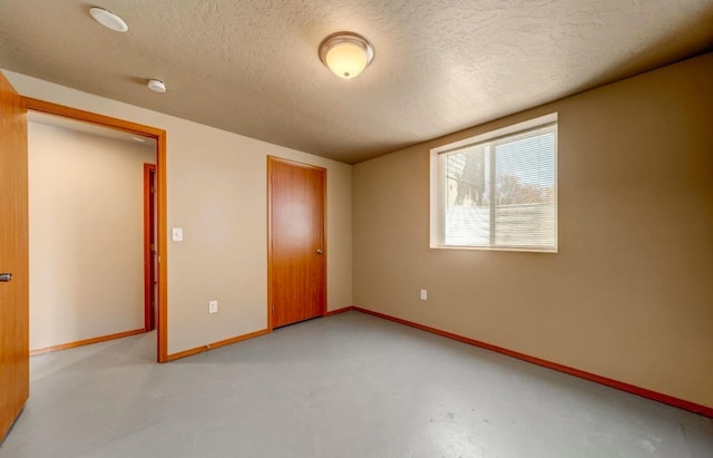 18 N 7th St, Cheney, WA 99004 - unfurnished bedroom with a textured ceiling, finished concrete floors, baseboards, and a closet