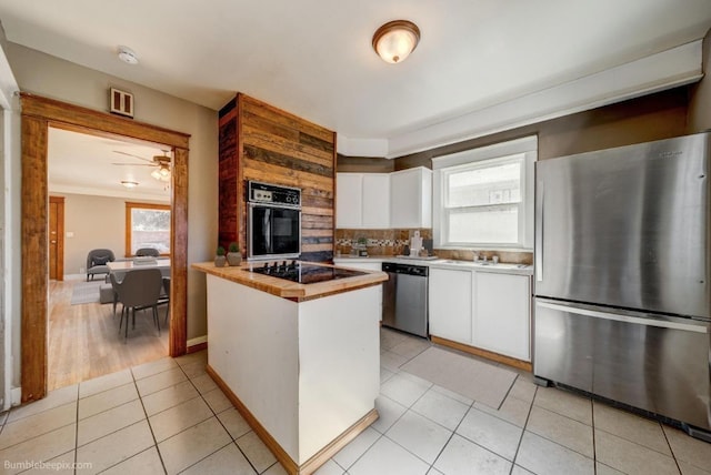 18 N 7th St, Cheney, WA 99004 - kitchen featuring black appliances, white cabinets, healthy amount of natural light, and backsplash