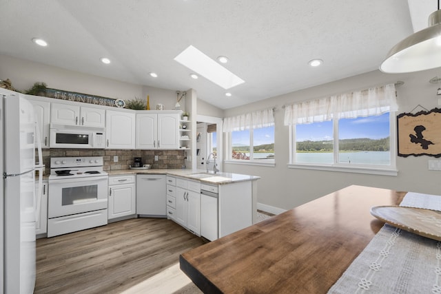 12621 N E Newman Lake Dr, Newman Lake, WA 99025 - kitchen with white appliances, a sink, a skylight, vaulted ceiling, and white cabinetry