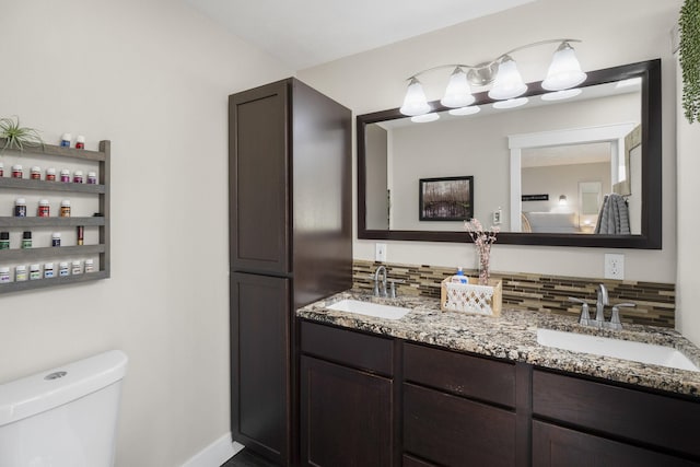 12621 N E Newman Lake Dr, Newman Lake, WA 99025 - full bathroom with double vanity, decorative backsplash, toilet, and baseboards