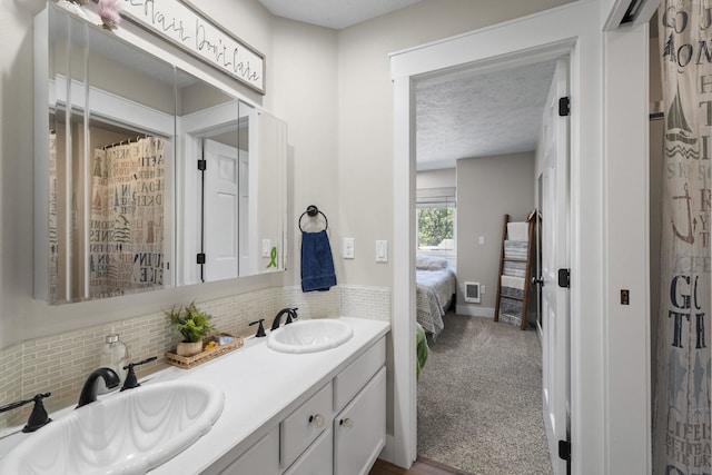 12621 N E Newman Lake Dr, Newman Lake, WA 99025 - ensuite bathroom with double vanity, decorative backsplash, and a textured ceiling