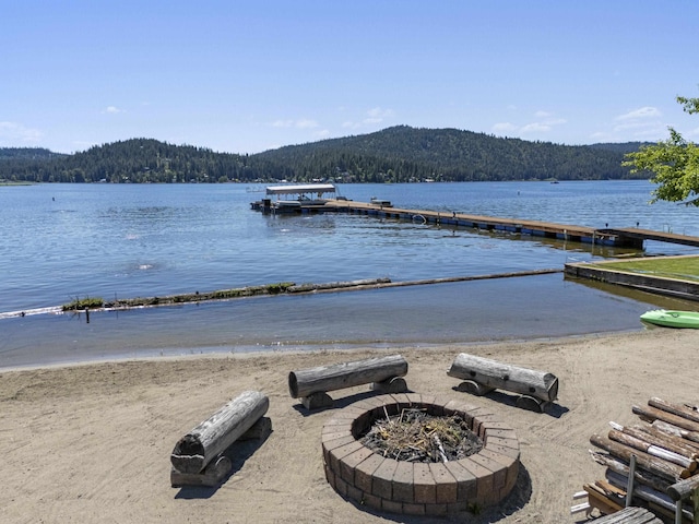 12621 N E Newman Lake Dr, Newman Lake, WA 99025 - water view with an outdoor fire pit, a heavily wooded area, and a boat dock