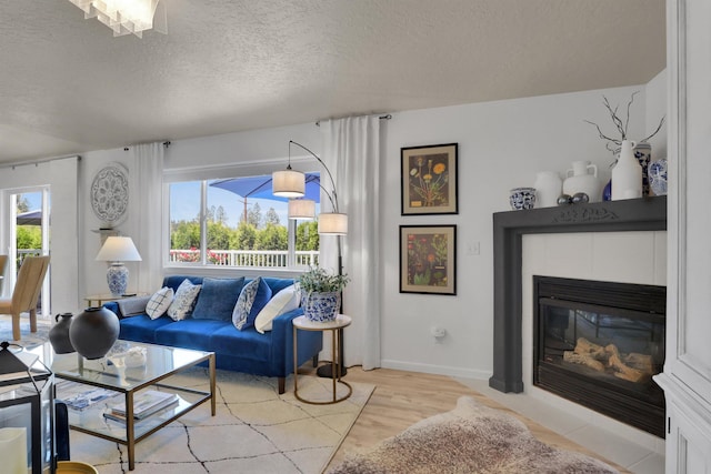 8310 E Bull Pine Ln, Spokane, WA 99217 - living area featuring a textured ceiling, light wood-style flooring, a fireplace, and baseboards