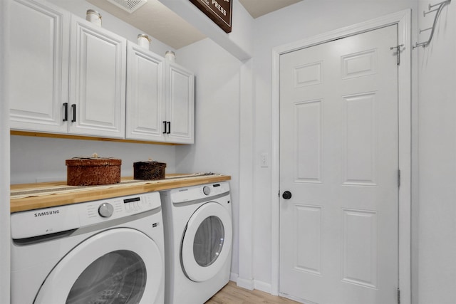 8310 E Bull Pine Ln, Spokane, WA 99217 - washroom featuring washer and clothes dryer, light wood-type flooring, and cabinet space