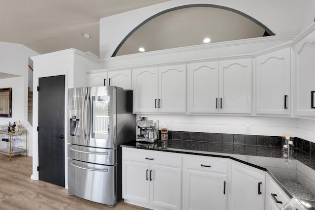 8310 E Bull Pine Ln, Spokane, WA 99217 - kitchen with stainless steel refrigerator with ice dispenser, white cabinetry, dark stone countertops, light wood-type flooring, and arched walkways
