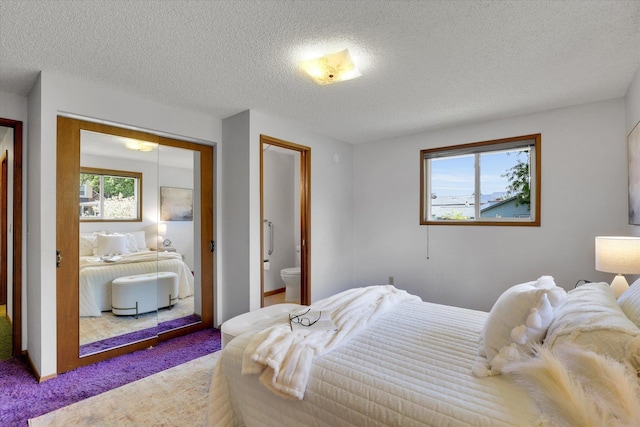 2651 E 35th Ave, Spokane, WA 99223 - bedroom featuring carpet, a textured ceiling, a closet, and ensuite bathroom