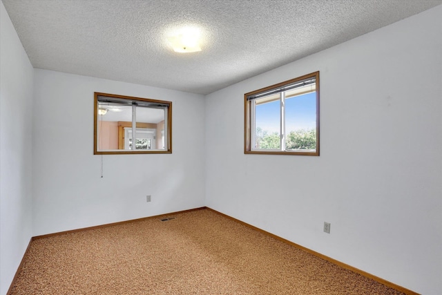 2651 E 35th Ave, Spokane, WA 99223 - carpeted empty room featuring healthy amount of natural light, a textured ceiling, and baseboards