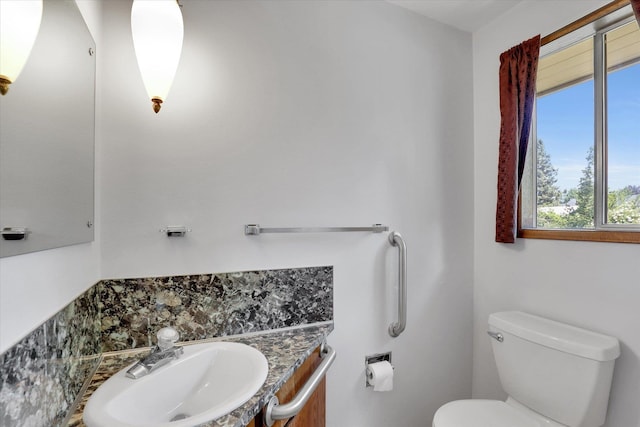 2651 E 35th Ave, Spokane, WA 99223 - half bath featuring toilet, vanity, and decorative backsplash