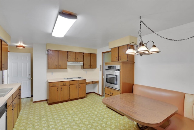 2651 E 35th Ave, Spokane, WA 99223 - kitchen featuring stainless steel oven, under cabinet range hood, stovetop, and brown cabinets