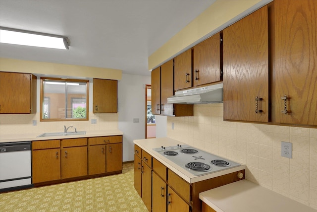 2651 E 35th Ave, Spokane, WA 99223 - kitchen featuring under cabinet range hood, white appliances, a sink, tasteful backsplash, and brown cabinetry