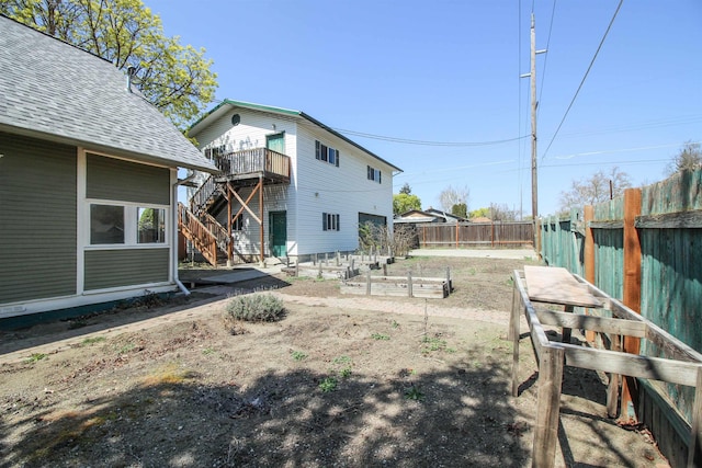 1427 E Bridgeport Ave, Spokane, WA 99207 - fenced backyard with a vegetable garden, stairs, and a deck