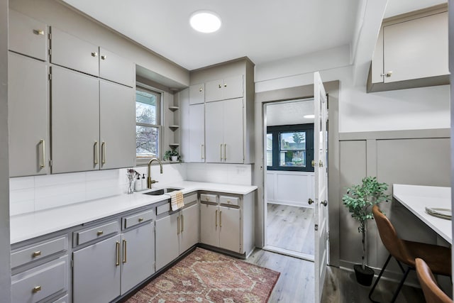 613 W Kiernan Ave, Spokane, WA 99205 - kitchen featuring gray cabinetry, a sink, plenty of natural light, light wood-style floors, and a decorative wall