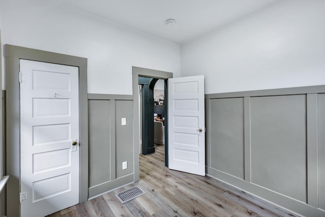 613 W Kiernan Ave, Spokane, WA 99205 - unfurnished bedroom with a decorative wall, wood finished floors, a wainscoted wall, and a closet