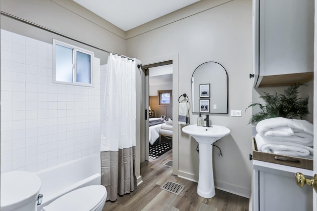 613 W Kiernan Ave, Spokane, WA 99205 - bathroom featuring toilet, wood finished floors, shower / bathtub combination with curtain, and baseboards