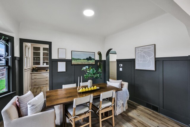 613 W Kiernan Ave, Spokane, WA 99205 - dining area featuring a wainscoted wall, wood finished floors, arched walkways, and plenty of natural light